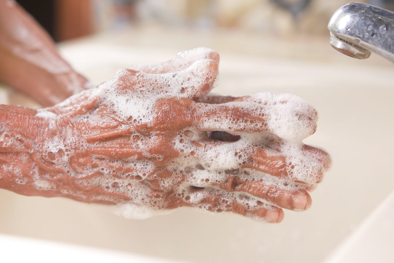 A detailed shot of hands covered in soap lather, highlighting hygiene and cleanliness.